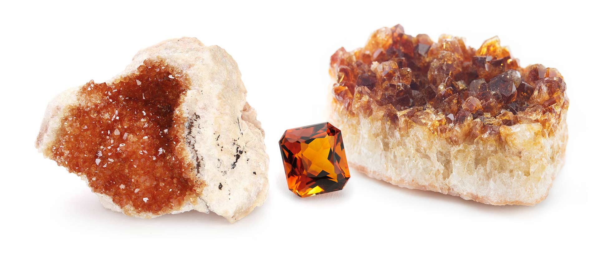 A cluster of rough citrine crystals alongside a faceted citrine gemstone specimen