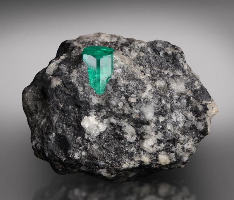 Emerald crystal in ore matrix, a gemological mineral specimen at the laboratory