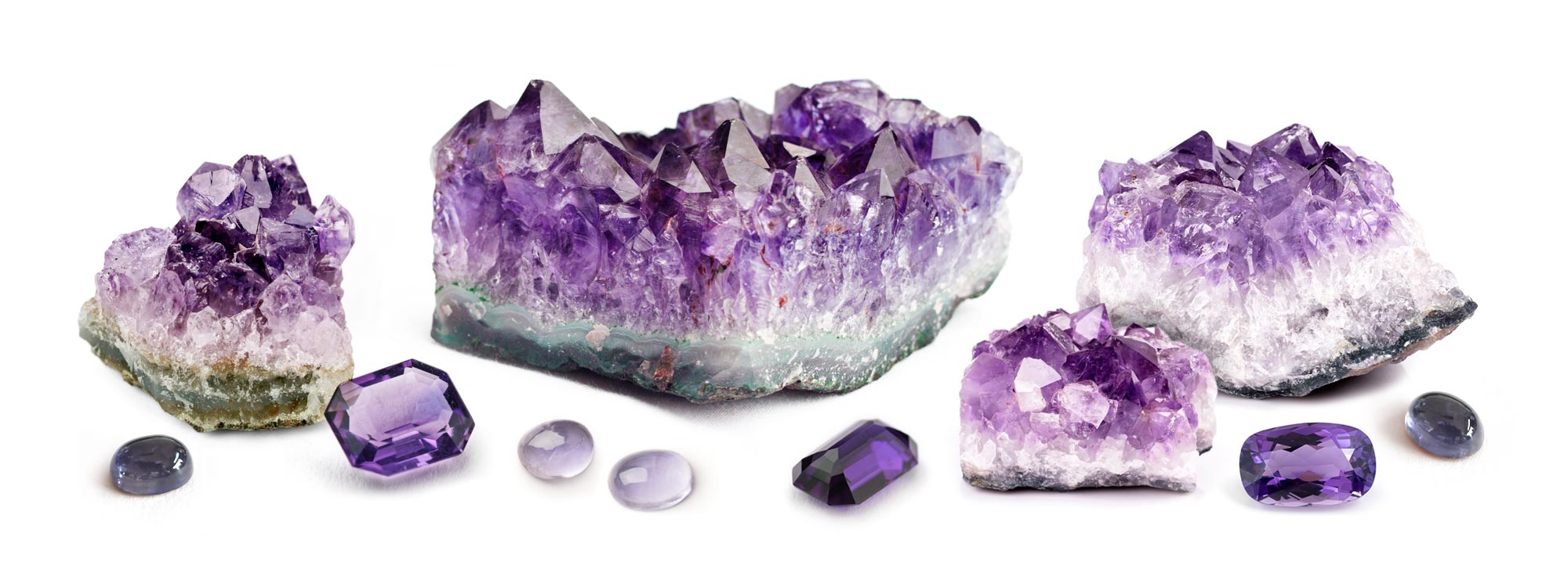 rough amethyst specimens with faceted stones and cabochons