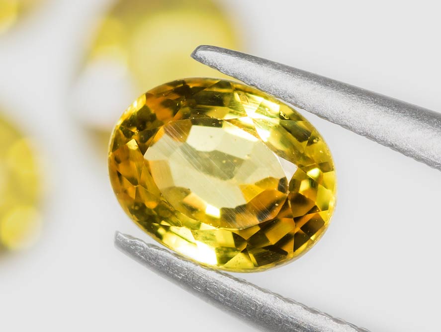 Citrine gemstone held by tweezers