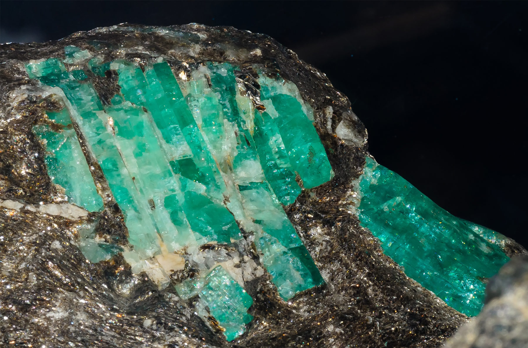 Group of raw emerald crystals in their host rock