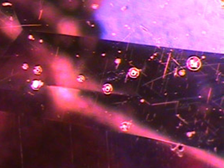 gas bubble inclusions inside a fracture-filled ruby